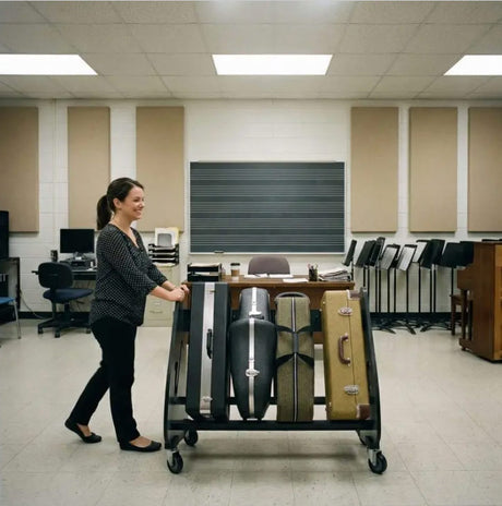 Woman pushing a cart with suitcases in a classroom setting