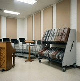 Room with a rack of suitcases and desks in the background