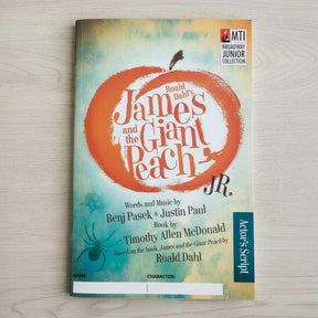 Book cover of 'James and the Giant Peach Jr.' on a wooden surface