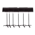A set of six black Manhasset orchestral music stands with adjustable desks and a tripod base.