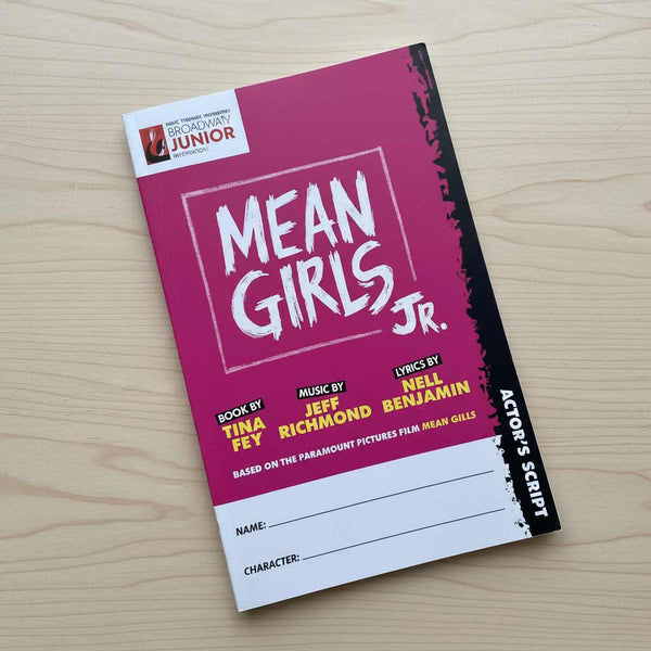 Actors script for 'Mean Girls Jr.' on a wooden surface